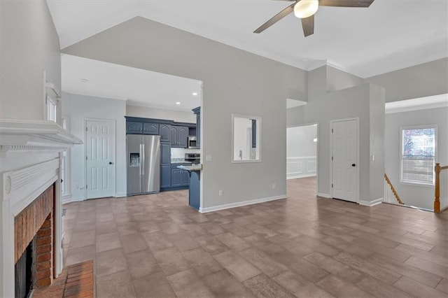 unfurnished living room featuring vaulted ceiling, a fireplace, baseboards, and ceiling fan