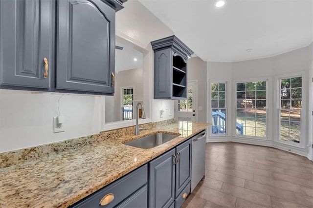 kitchen featuring dishwasher, light stone counters, open shelves, a sink, and recessed lighting