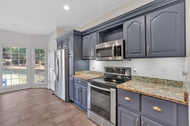 kitchen featuring recessed lighting, appliances with stainless steel finishes, light stone counters, and ornamental molding