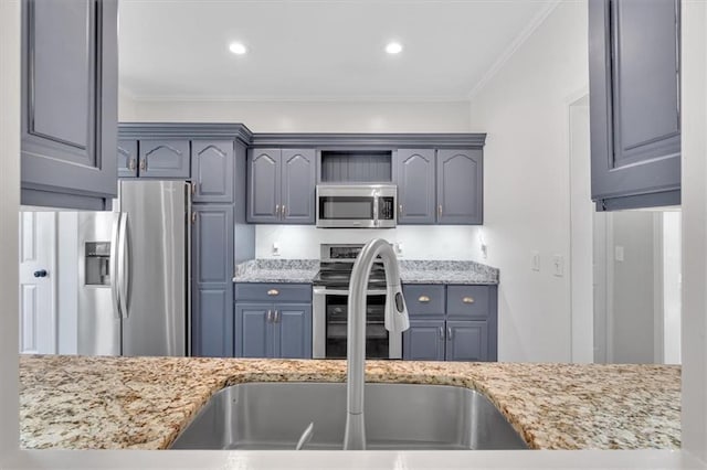 kitchen featuring light stone countertops, ornamental molding, stainless steel appliances, and a sink