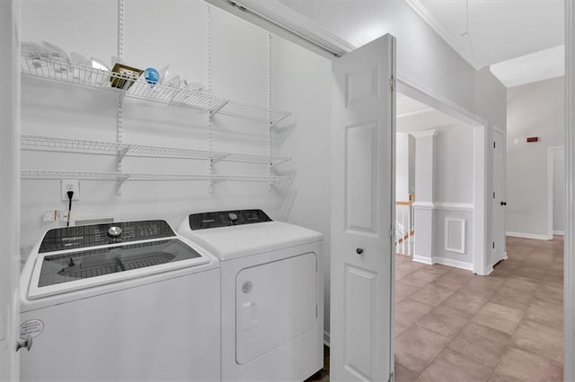 clothes washing area featuring washing machine and dryer, laundry area, and baseboards