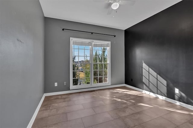 unfurnished room featuring ceiling fan and baseboards