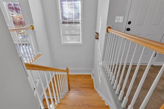 staircase featuring plenty of natural light, baseboards, and wood finished floors