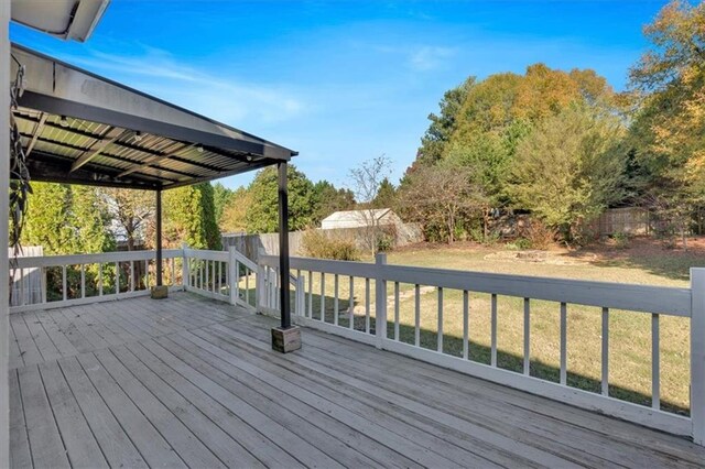 wooden terrace with a fenced backyard and a lawn