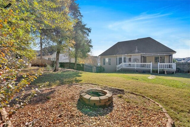 back of property with a yard, a fenced backyard, and a wooden deck