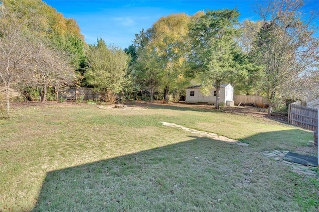 view of yard featuring an outbuilding, a shed, and fence private yard