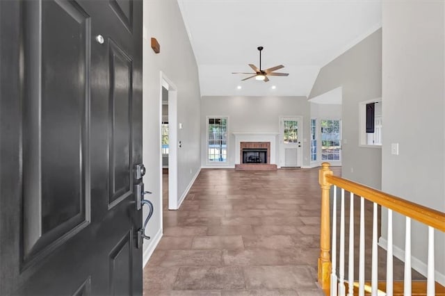 entryway with ceiling fan, high vaulted ceiling, a fireplace, and baseboards