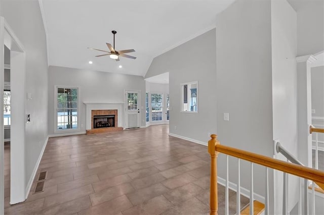 unfurnished living room featuring a brick fireplace, a healthy amount of sunlight, and baseboards