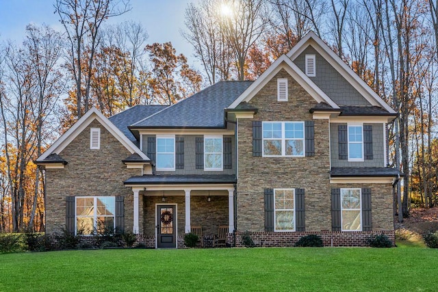 craftsman-style house featuring stone siding and a front lawn