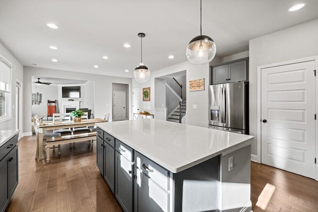 kitchen featuring recessed lighting, dark wood-style flooring, light countertops, and stainless steel fridge with ice dispenser