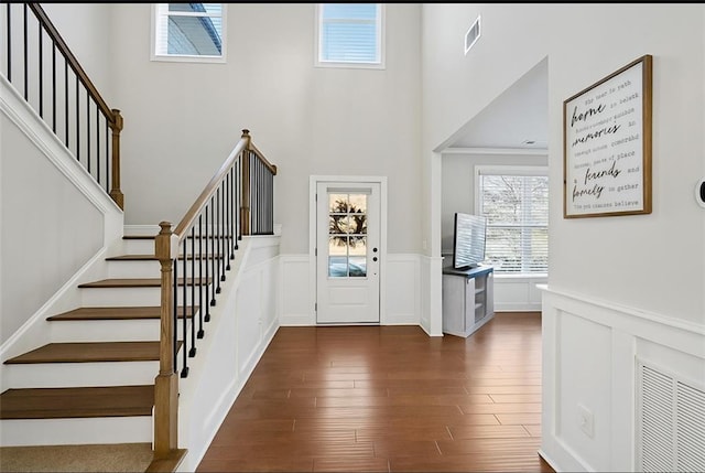 69 Saint Ives Cir, Winder, GA 30680 - entryway with a wainscoted wall, stairway, a towering ceiling, a decorative wall, and dark wood-style flooring