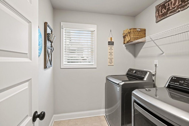 clothes washing area with laundry area, baseboards, and washing machine and clothes dryer