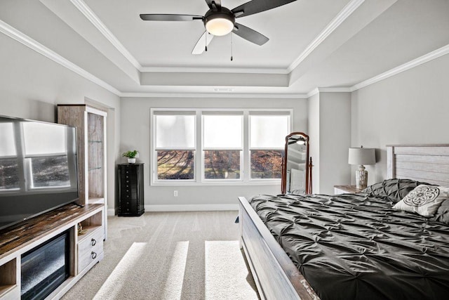 bedroom featuring baseboards, a raised ceiling, light colored carpet, ceiling fan, and ornamental molding