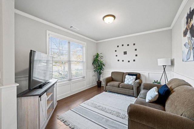 living room featuring ornamental molding, wainscoting, dark wood finished floors, and visible vents