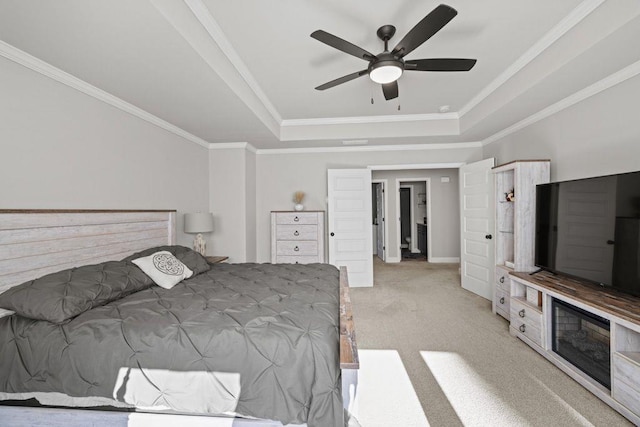 bedroom featuring ornamental molding, a raised ceiling, carpet flooring, and a ceiling fan