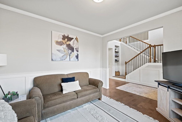 living room with stairs, ornamental molding, wood finished floors, and wainscoting