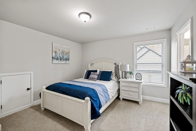 bedroom featuring light carpet, visible vents, and baseboards