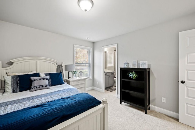 bedroom featuring light carpet, baseboards, and connected bathroom