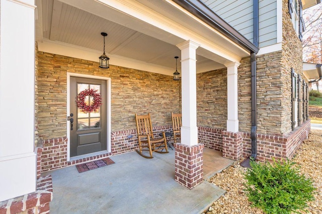 property entrance featuring a porch and stone siding