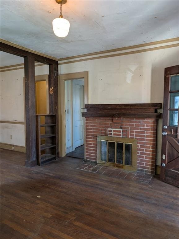 unfurnished living room featuring ornamental molding, dark wood-type flooring, and a fireplace