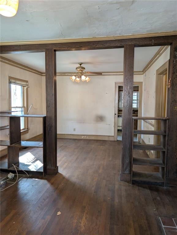 interior space with baseboards, wood finished floors, and crown molding