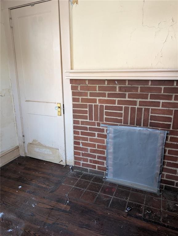 details featuring a brick fireplace and wood finished floors