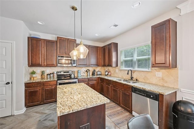 7530 Springbox Dr, Fairburn, GA 30213 - kitchen featuring appliances with stainless steel finishes, light stone counters, a center island, decorative light fixtures, and recessed lighting