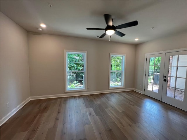 spare room with ceiling fan, dark wood-type flooring, and a healthy amount of sunlight