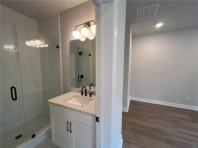 bathroom featuring walk in shower, hardwood / wood-style flooring, and vanity