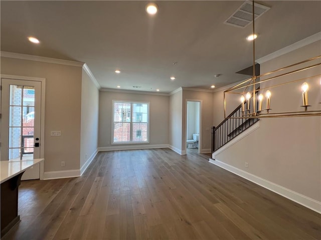 unfurnished living room featuring a notable chandelier, crown molding, and dark wood-type flooring