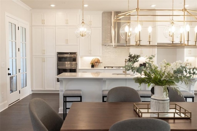 dining space with an inviting chandelier, crown molding, and dark wood-type flooring