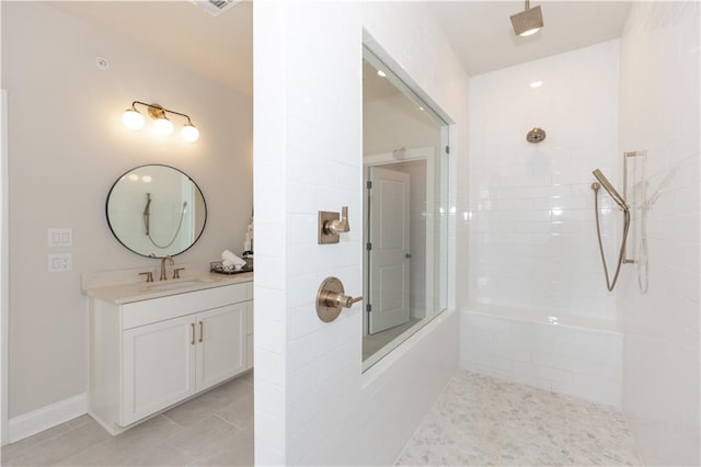 bathroom with tile flooring, large vanity, and tiled shower / bath