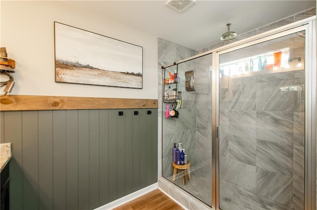 full bath featuring a wainscoted wall, a shower stall, and visible vents