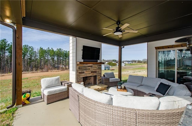 view of patio / terrace featuring a ceiling fan and an outdoor living space with a fireplace