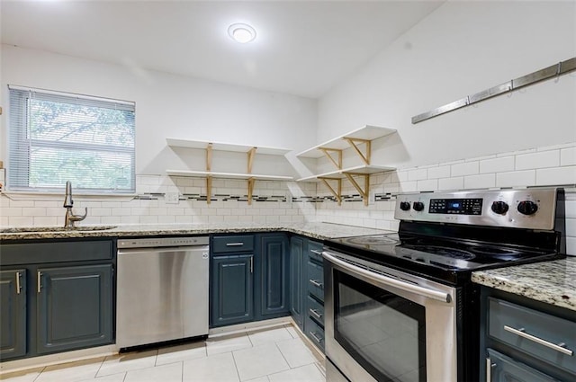 kitchen featuring stainless steel appliances, light stone countertops, sink, and decorative backsplash