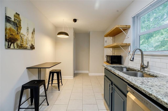 kitchen featuring light stone countertops, sink, light tile patterned flooring, dishwasher, and backsplash