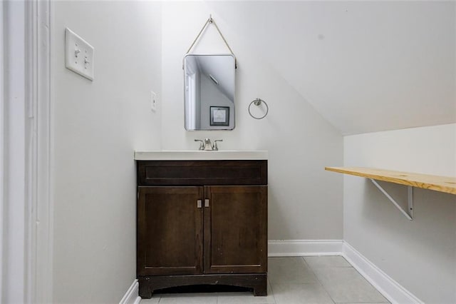 bathroom with vanity, lofted ceiling, and tile patterned floors