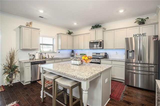 3469 English Elm Way, Loganville, GA 30052 - kitchen with visible vents, crown molding, dark wood finished floors, appliances with stainless steel finishes, and a center island