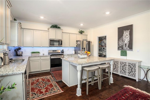 3469 English Elm Way, Loganville, GA 30052 - kitchen featuring ornamental molding, stainless steel appliances, a kitchen island, dark wood finished floors, and backsplash