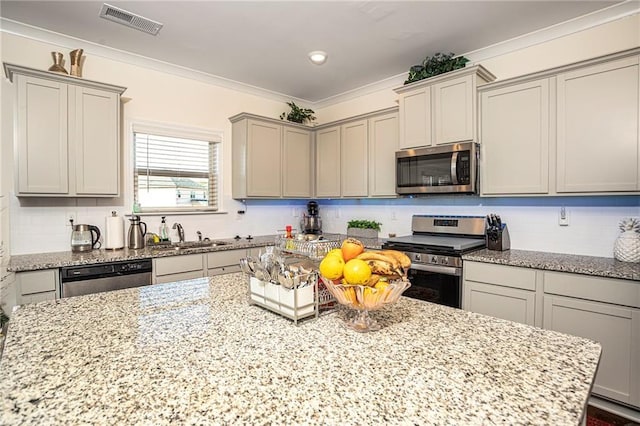 3469 English Elm Way, Loganville, GA 30052 - kitchen with crown molding, a sink, visible vents, light stone countertops, and appliances with stainless steel finishes