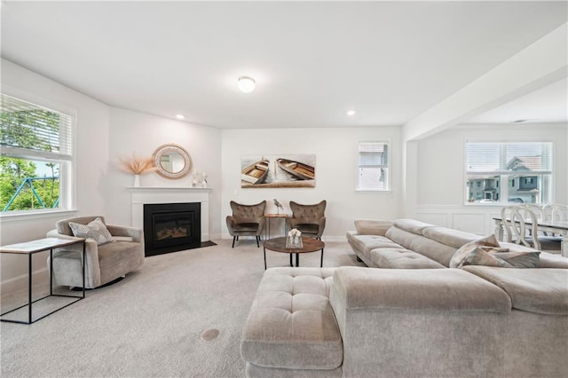 carpeted living area featuring recessed lighting and a fireplace with flush hearth