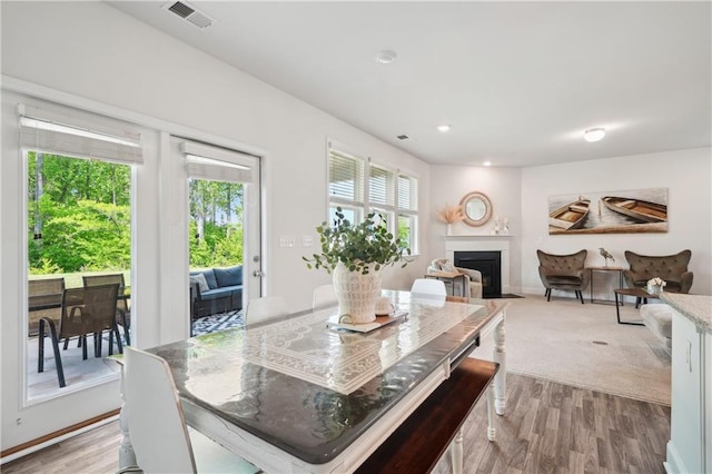 dining room featuring visible vents, a fireplace, baseboards, recessed lighting, and light wood-type flooring