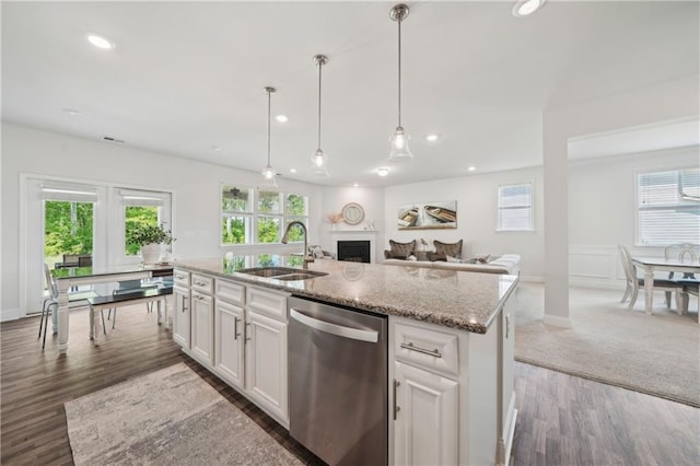 kitchen with light stone countertops, recessed lighting, a sink, dark wood finished floors, and dishwasher