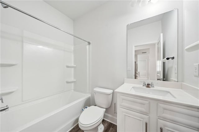 bathroom featuring shower / bathing tub combination, wood finished floors, vanity, baseboards, and toilet