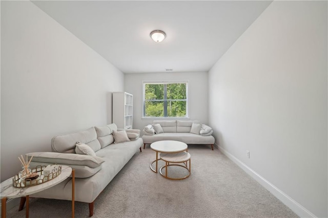 carpeted living area with baseboards