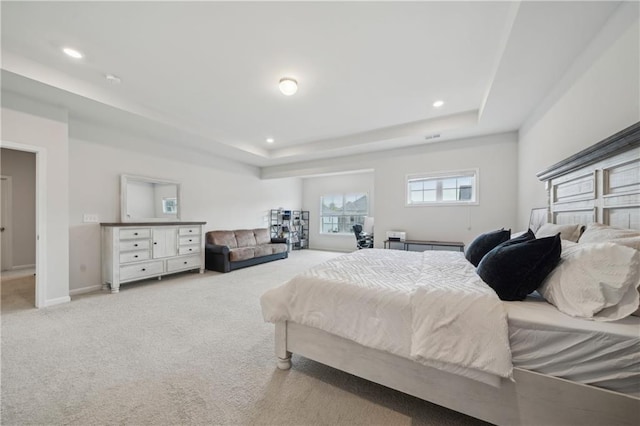 bedroom with recessed lighting, carpet flooring, and a tray ceiling