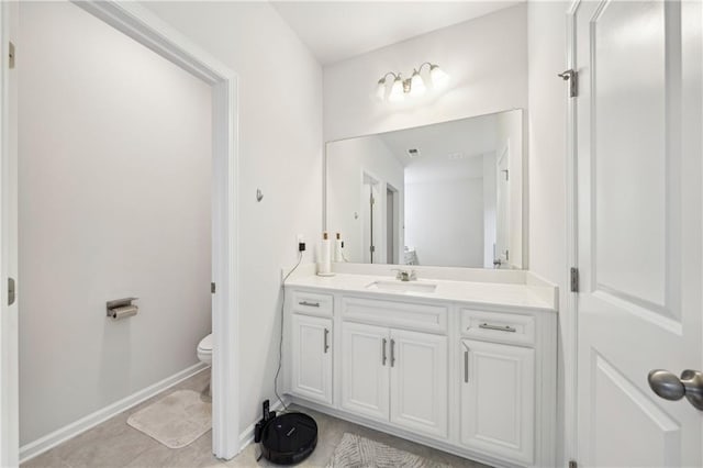 bathroom featuring toilet, baseboards, tile patterned floors, and vanity