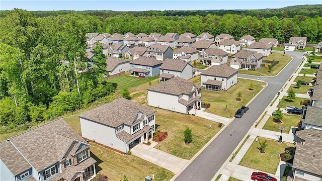 drone / aerial view featuring a forest view and a residential view