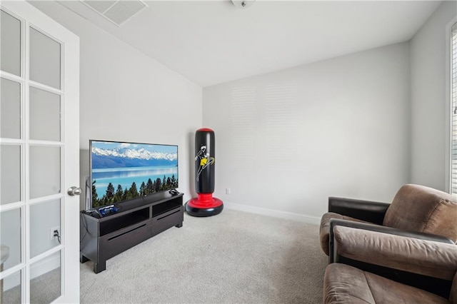 sitting room with visible vents, carpet flooring, baseboards, and vaulted ceiling