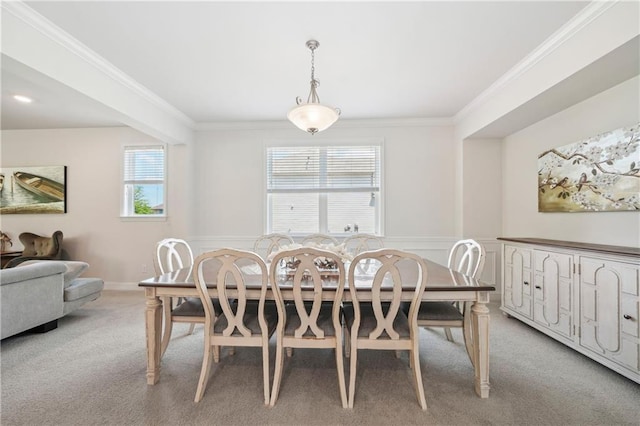 dining space featuring carpet floors, ornamental molding, and a wainscoted wall